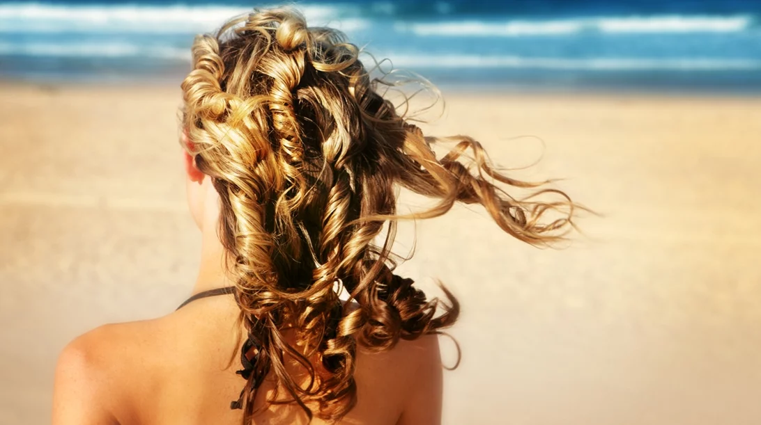 Γιατί τα μαλλιά σγουραίνουν το καλοκαίρι; Όλη η εξήγηση πίσω από τη δομή της τρίχας