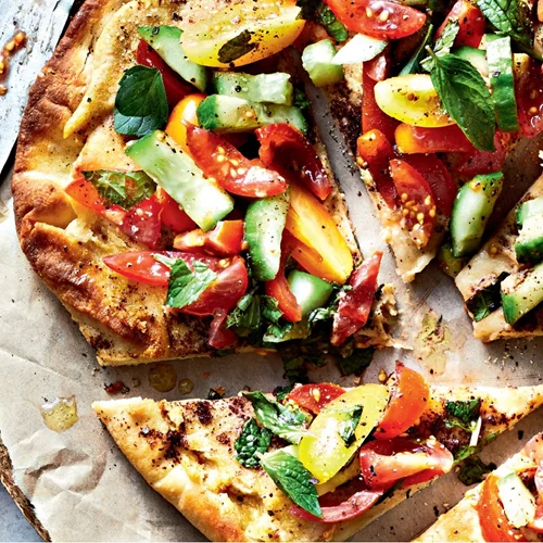 Ιδανικό και υγιεινό γεύμα: Πίτσα με χούμους, ντοματίνια, αγγούρι και σάλτσα δυόσμου