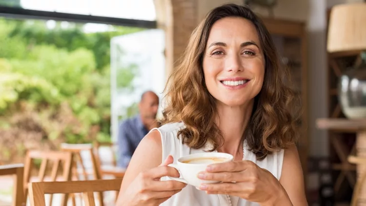 Γυναίκα που κρατάει ένα φλιτζάνι με καφέ - βλάπτει ο καφές το γλαύκωμα;