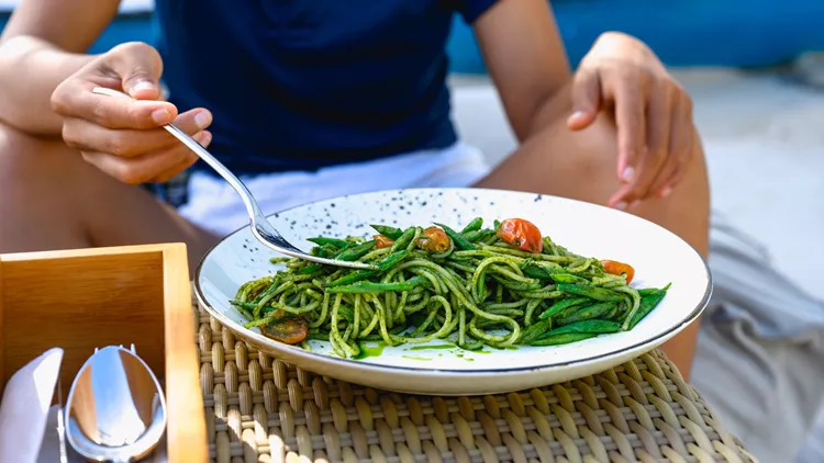 γυναίκα τρώει από πιάτο τροφές με σίδηρο