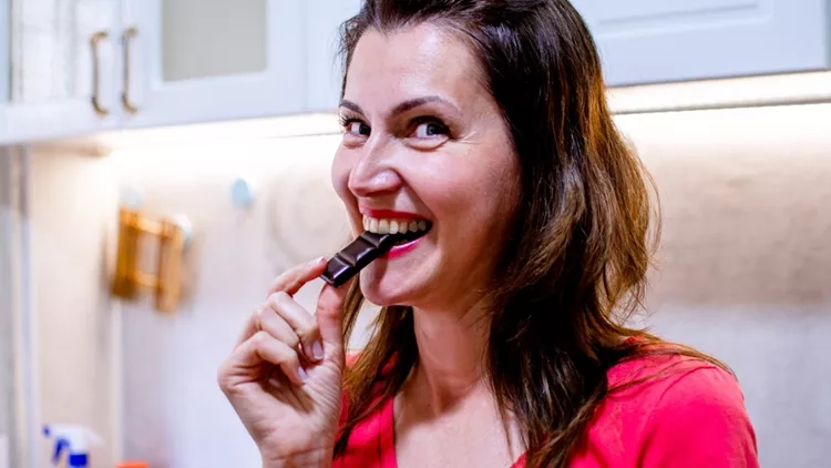 Γυναίκα στην προεμμηνόπαυση που τρώει σοκολάτα