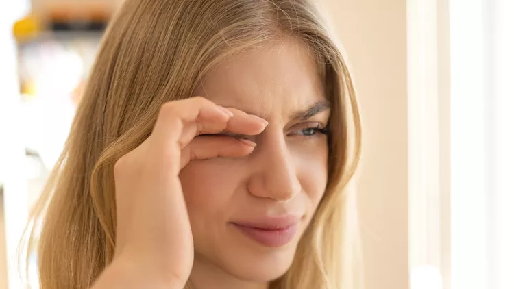 γυναίκα τρίβει τα μάτια με επιπεφυκίτιδα