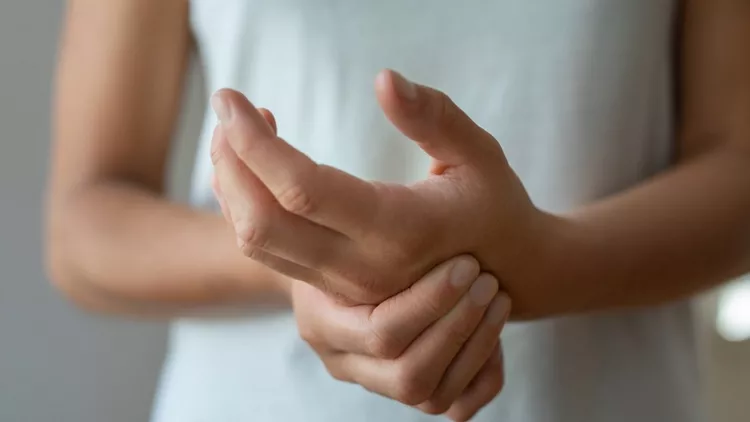 Γυναίκα που κρατάει το χέρι της - πόνος στις αρθρώσεις - αυτοάνοσα