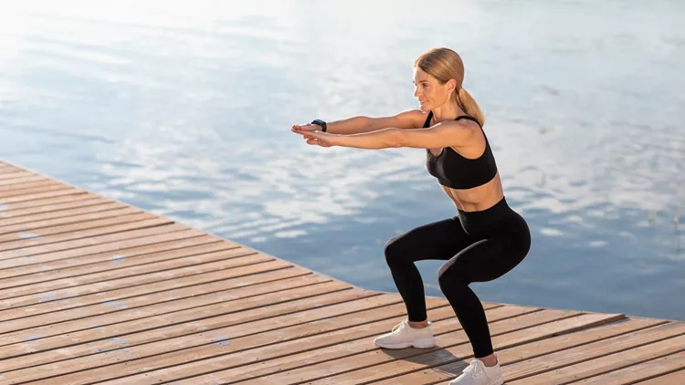 γυναίκα κάνει squat λυγίζοντας τα γόνατα