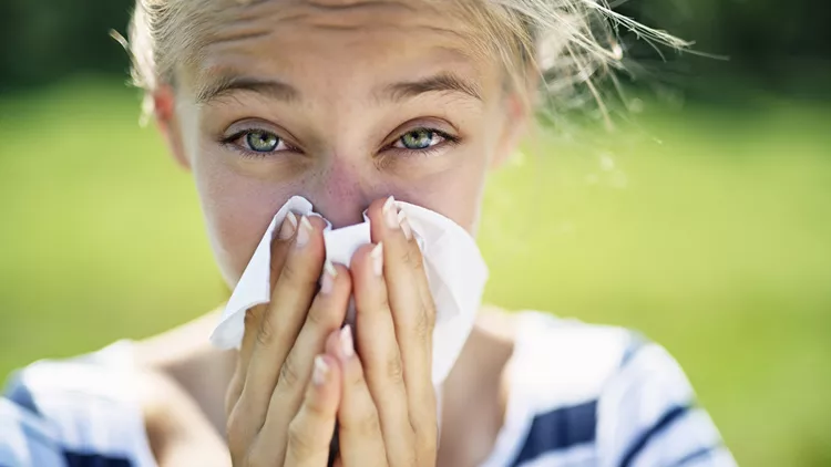 γυναίκα με μαντίλι στη μύτη πάσχει από αλλεργίες