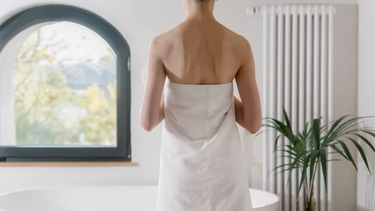 Γυναίκα τυλιγμένη σε πετσέτα μπροστά στον καθρέφτη - έρπης ζωστήρας