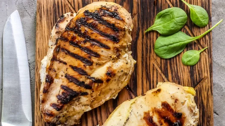 grilled-chicken-fillets-on-wooden-cutting-board-picture-id958952754