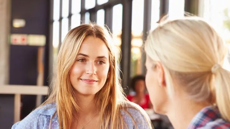 two-female-friends-talking-at-a-coffee-shop-picture-id478406876