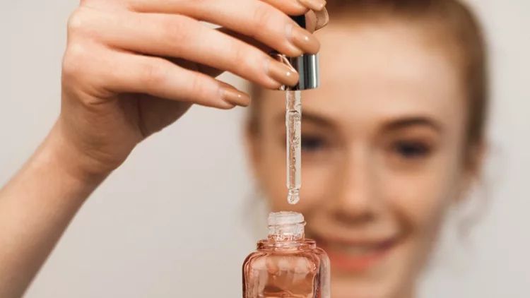 close-up-hand-of-a-young-woman-holding-a-dropper-and-a-bottle-with-picture-id1191583749