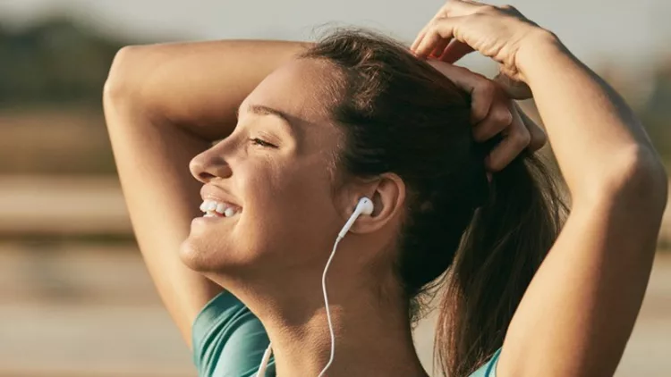 female-jogger-listening-to-music-while-preparing-for-run-picture-id943891260