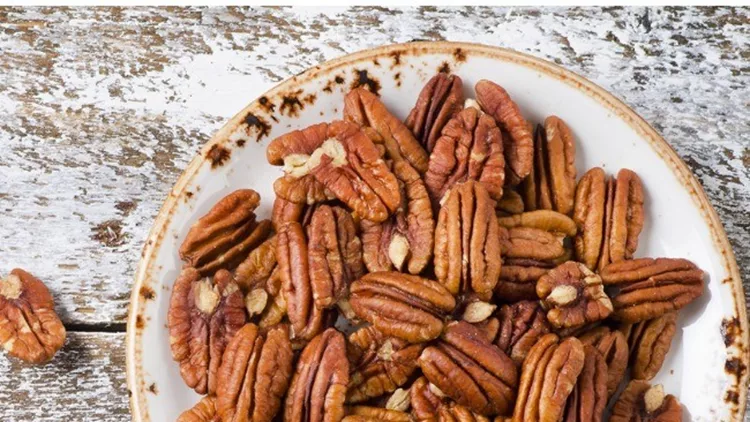 pecan-nuts-on-a-wooden-table-picture-id615990106