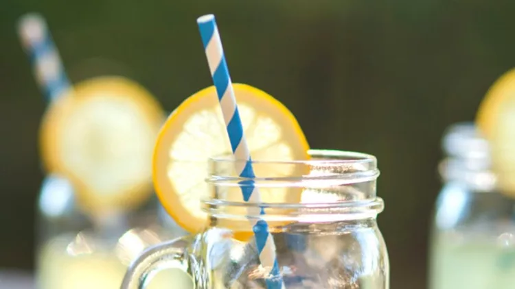 lemonade-glass-jars-with-lemon-wedges-and-straws-picture-id622893286