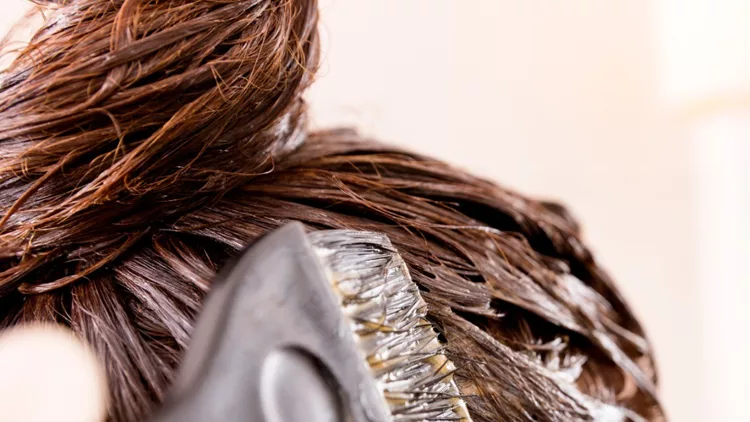 woman-with-dying-her-hair-in-front-of-mirror-in-her-own-bathroom-picture-id824312262