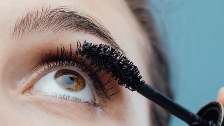 woman-applying-mascara-on-her-lashes-picture-id938427448