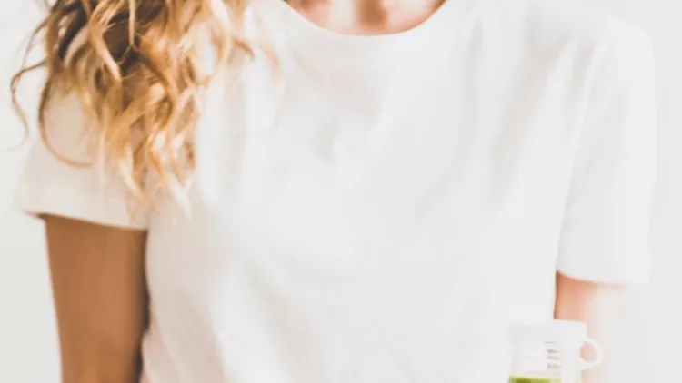woman-holding-vegan-superbowl-and-green-smoothie-in-hands-picture-id1138775170