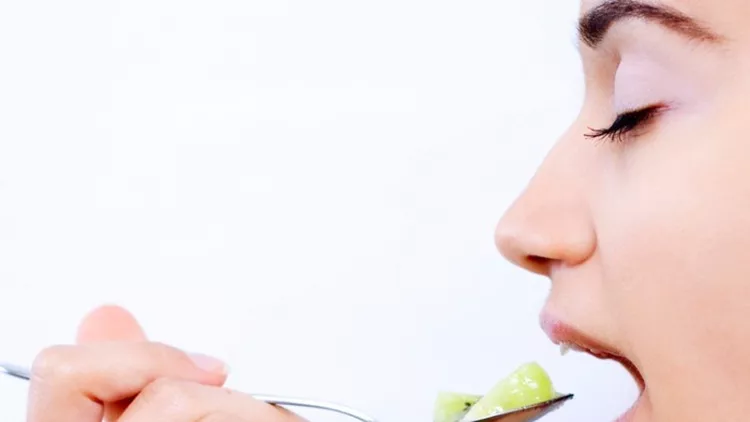 young-woman-eating-kiwi-picture-id173644896