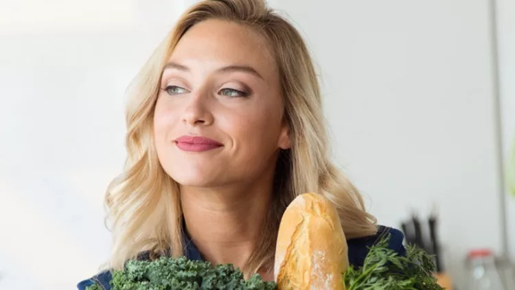 beautiful-young-woman-grocery-shopping-bag-with-vegetables-at-home-picture-id964373342
