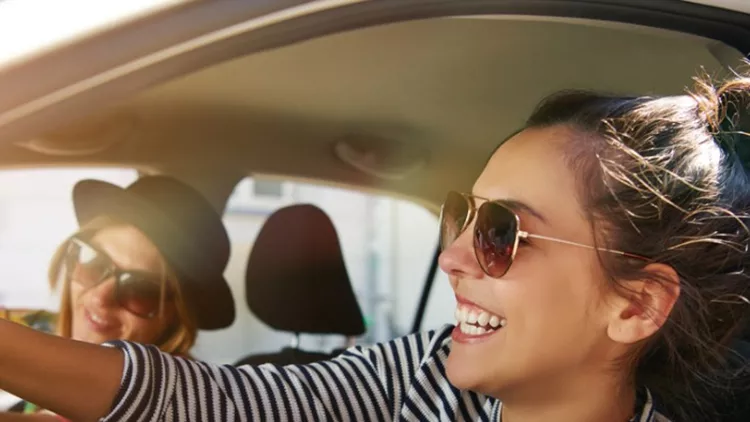 two-laughing-young-girlfriends-driving-together-in-a-car-picture-id832085296