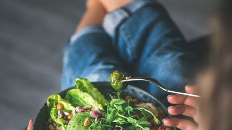 woman-sitting-at-home-and-eating-vegan-superbowl-picture-id1139470588