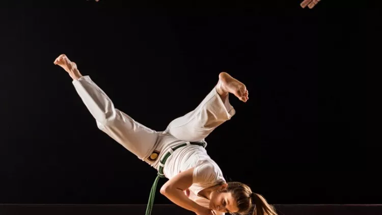 athletic-woman-exercising-handstand-on-capoeira-training-in-a-health-picture-id929489858