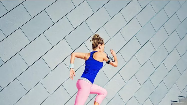 girl-is-runing-on-the-city-stairs-and-listening-the-music-picture-id825721894