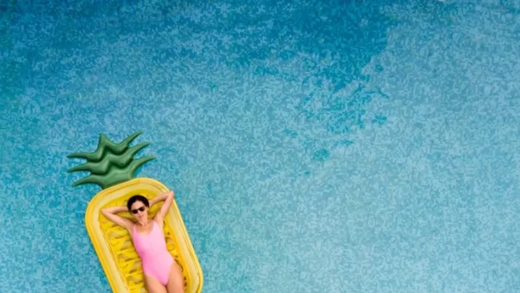 carefree-woman-on-inflatable-pineapple-picture-id849731176