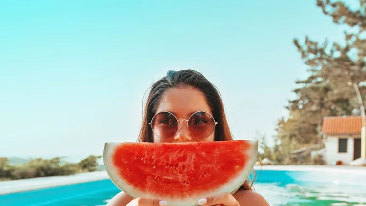 beautiful-attractive-woman-enjoying-in-the-pool-holding-a-watermelon-picture-id1135334448