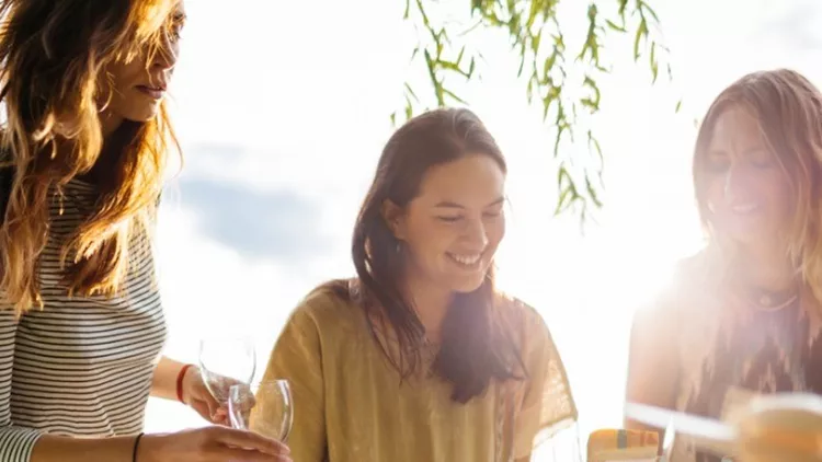 young-women-preparing-a-table-for-an-outdoor-dinner-party-picture-id607600720