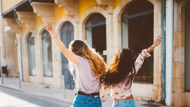 young-hipster-women-on-holidays-walking-cheerfully-in-old-streets-picture-id802496998