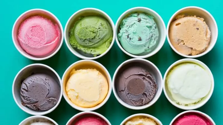 top-view-ice-cream-flavors-in-cup-on-green-background-picture-id669244394