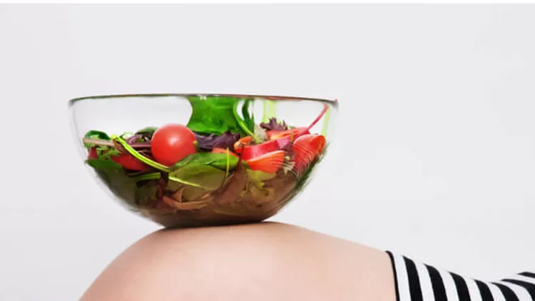 pregnant-woman-with-a-bowl-of-vegetables-picture-id534896493