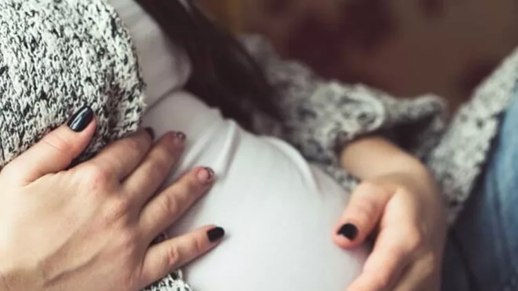 young-pregnant-woman-sitting-on-sofa-close-up-picture-id657442234