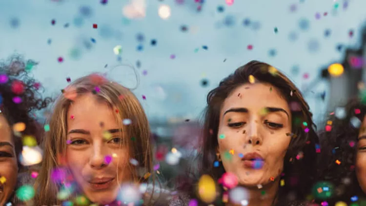 young-women-blowing-confetti-from-hands-picture-id858790856