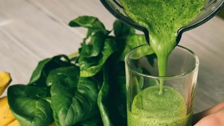 female-hand-pours-a-smoothie-of-banana-and-spinach-picture-id500573608