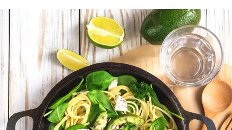 fettuccine-pasta-with-sliced-avocado-feta-cheese-spinach-picture-id623667604