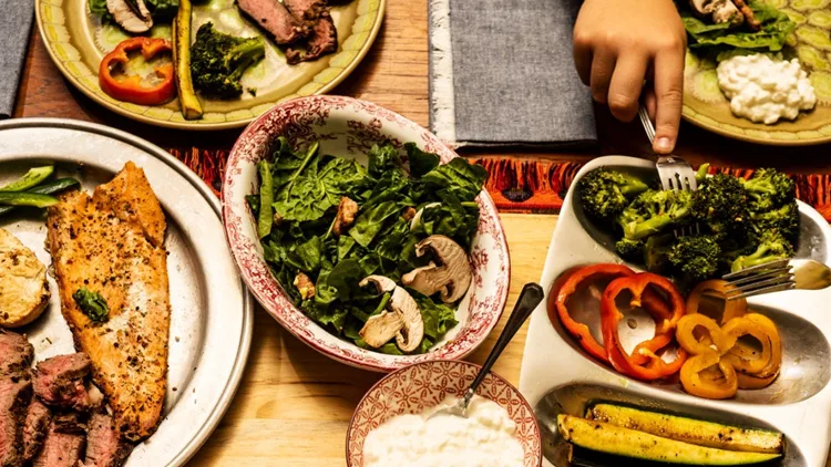 ketogenic-meal-laid-out-on-a-dining-table-with-the-hands-of-people-picture-id1026234194
