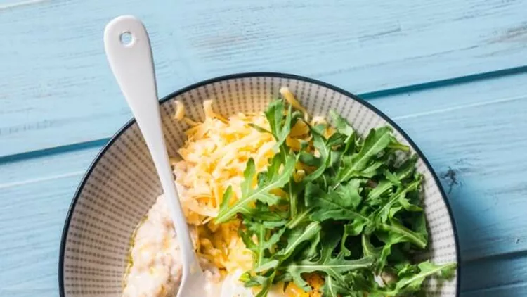 savoury-oatmeal-with-fried-egg-arugula-and-cheese-delicious-healthy-picture-id886084470