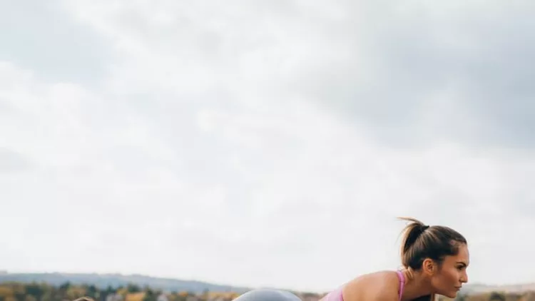 fit-young-women-in-a-plank-position-at-the-lake-pier-picture-id936912340
