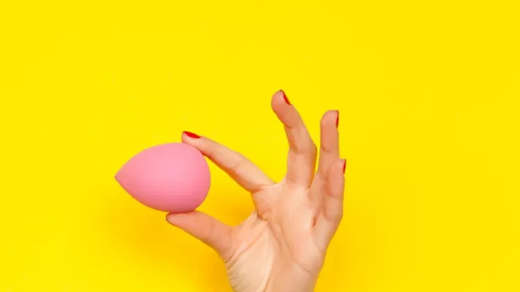 hand-holding-cosmetic-sponge-picture-id811400768