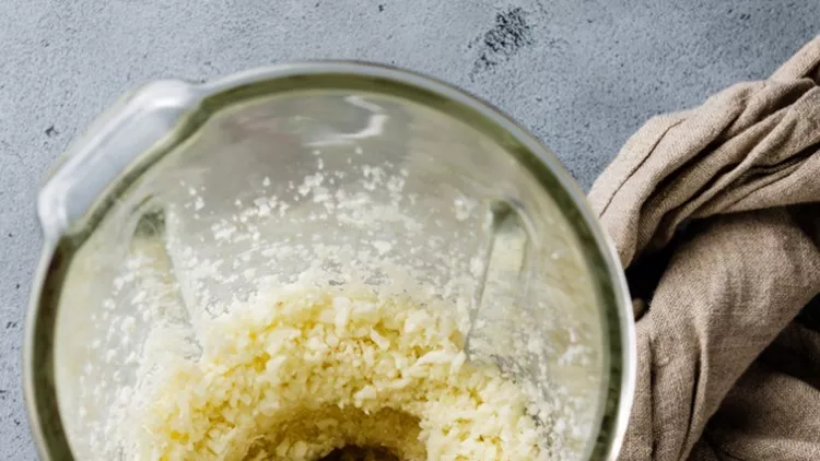 raw-cauliflower-ground-in-food-processor-for-making-cauliflower-rice-picture-id1073006740