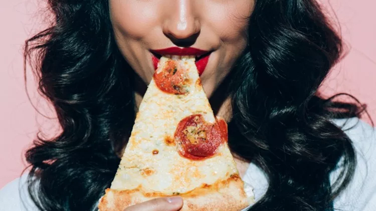 cropped-shot-of-woman-eating-pizza-on-pink-background-picture-id942927444
