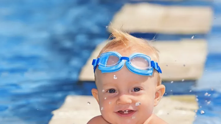 happy-child-playing-with-water-splashes-in-pool-picture-id473665920