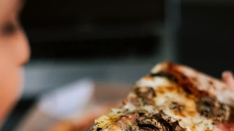 eating-pizza-at-night-closeup-picture-id912663922