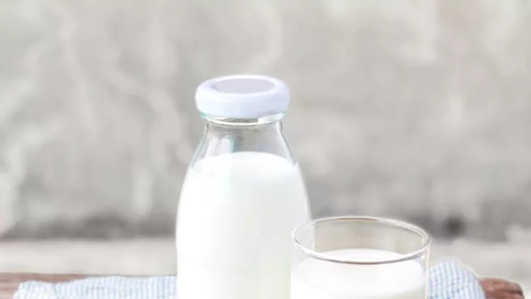 glass-of-milk-and-bottle-of-milk-on-the-wood-table-picture-id854296630