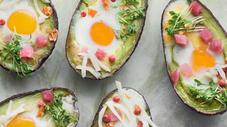 keto-diet-dish-avocado-boats-with-ham-cubes-quail-eggs-cheese-and-picture-id1082292822