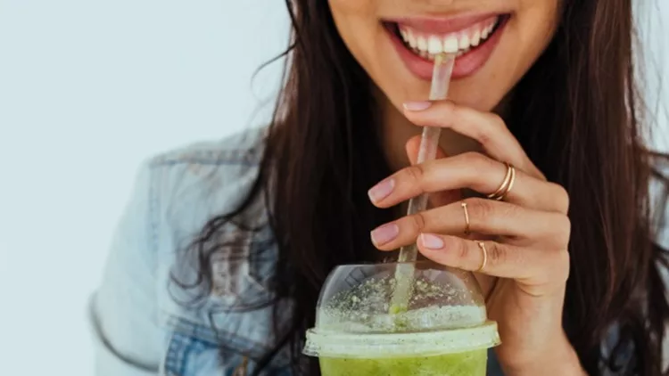 smiling-woman-drinking-fresh-juice-picture-id943885320