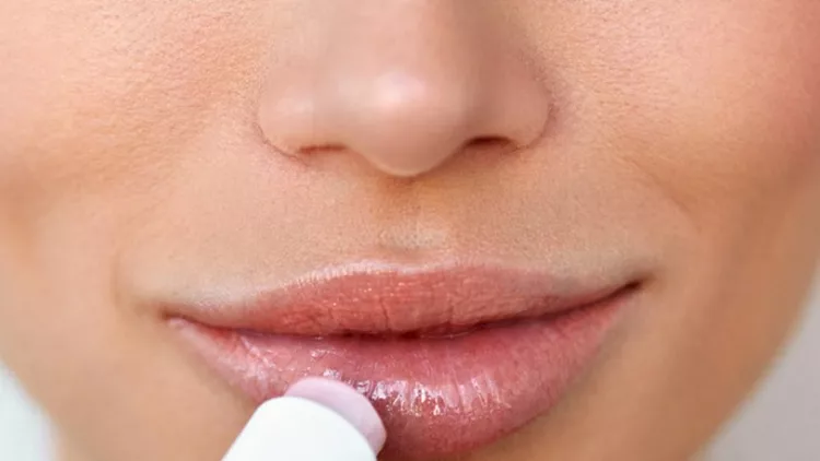 beautiful-woman-applying-lip-protector-on-lips-skin-beauty-picture-id943062500