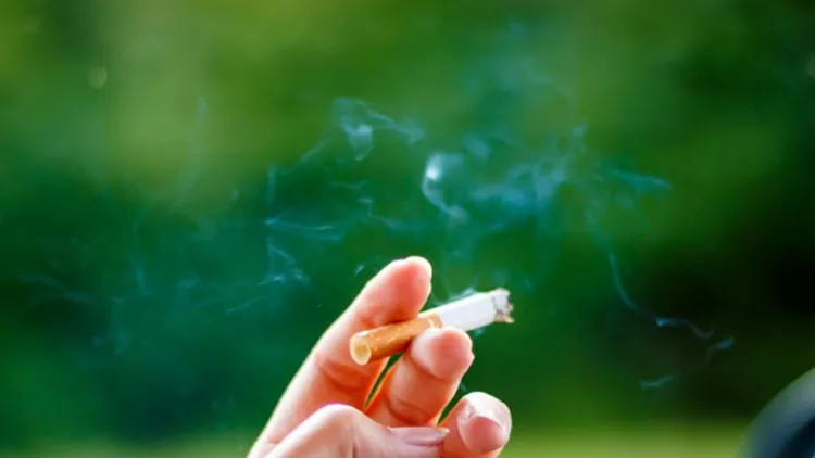 woman-smoking-a-cigarette-at-the-wheel-of-a-car-picture-id870800352