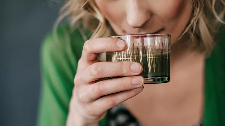 Young woman drinking green juice