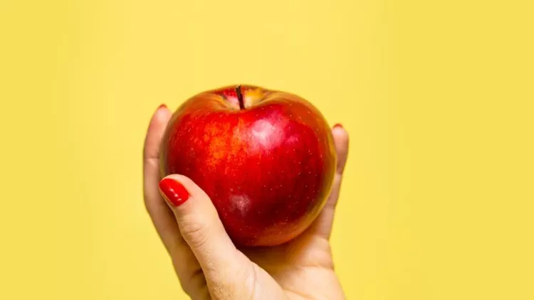 an-apple-in-a-hand-picture-id860396588